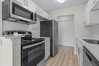 A kitchen with a black refrigerator and stove.